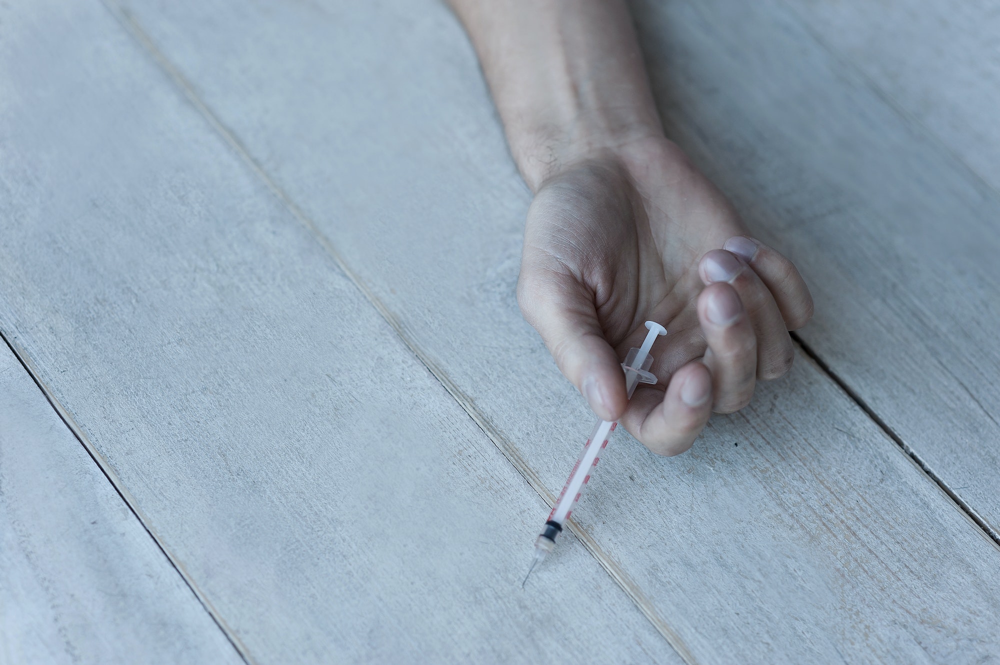 Death in his hand. Close-up of hand holding syringe with narcotic